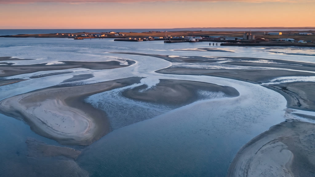 Winding tidal channels between sandbanks, seen from above at first light.